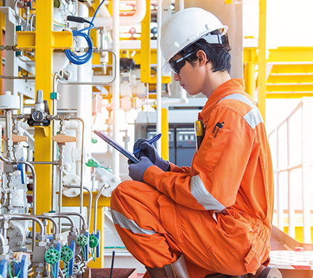 man kneeling down performing maintenance checks on equipment