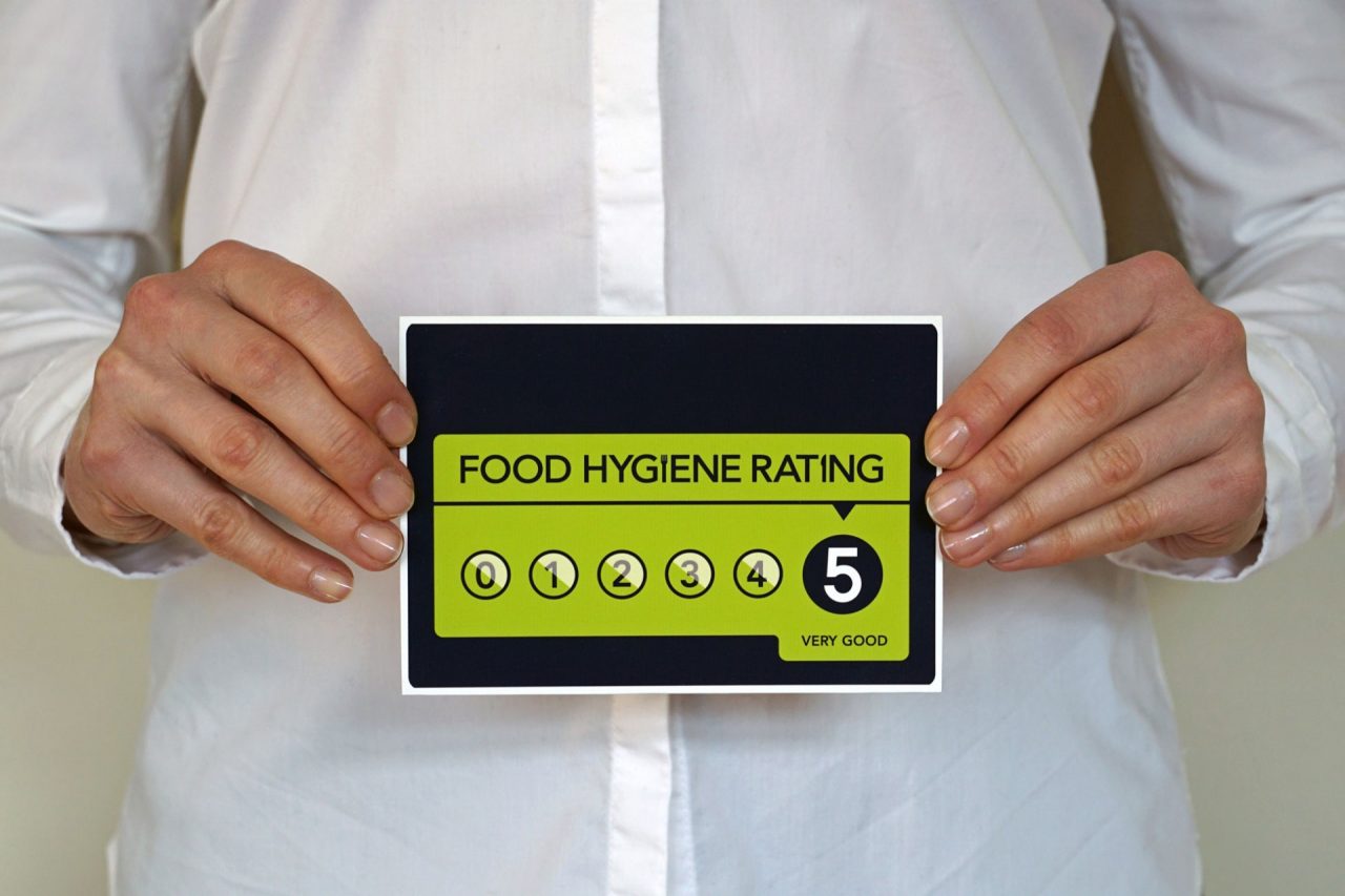 Restaurant Manager holds Food Hygiene Rating 5 sticker