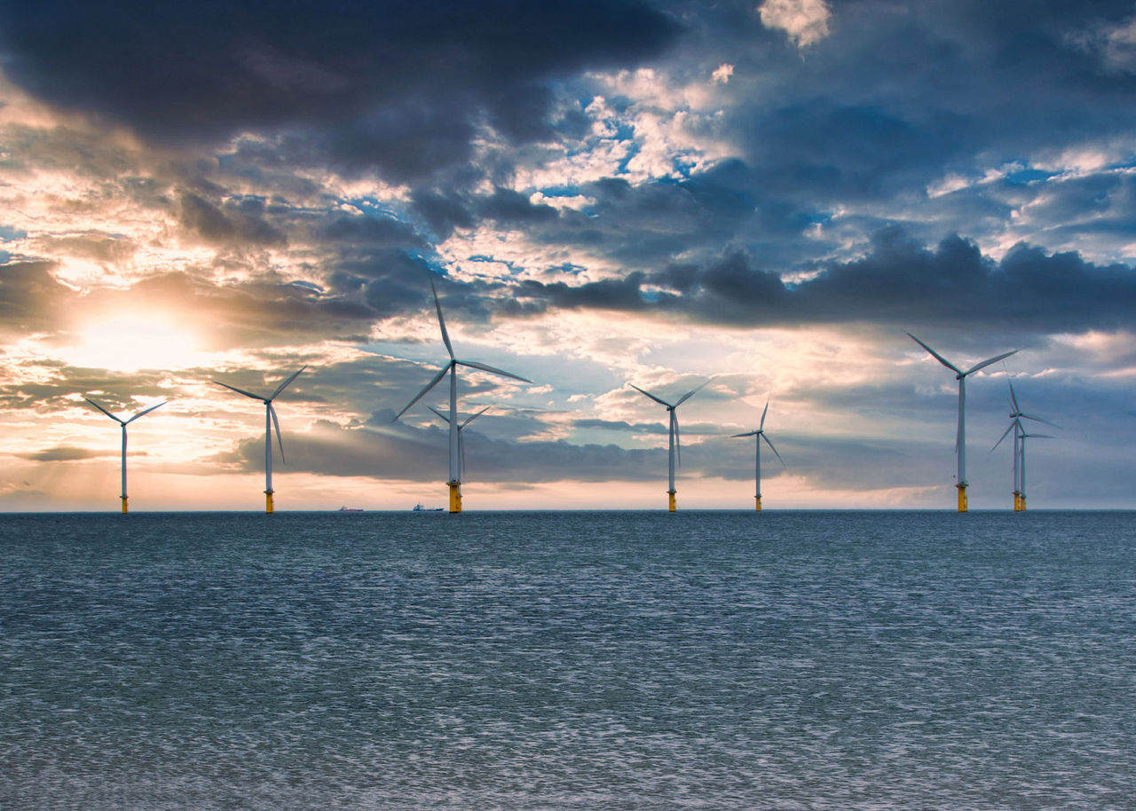 Great British Energy: Green Revolution or Government Repetition? Offshore Wind Turbine in a Windfarm under construction off the England Coast at sunset