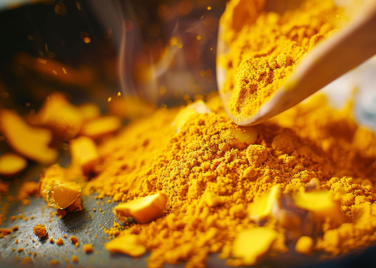 Close-up of turmeric powder being added to a dish, vibrant and healthy