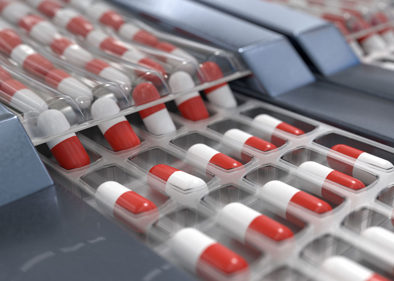 Red and white capsules in pharmaceutical production line. 3D ren