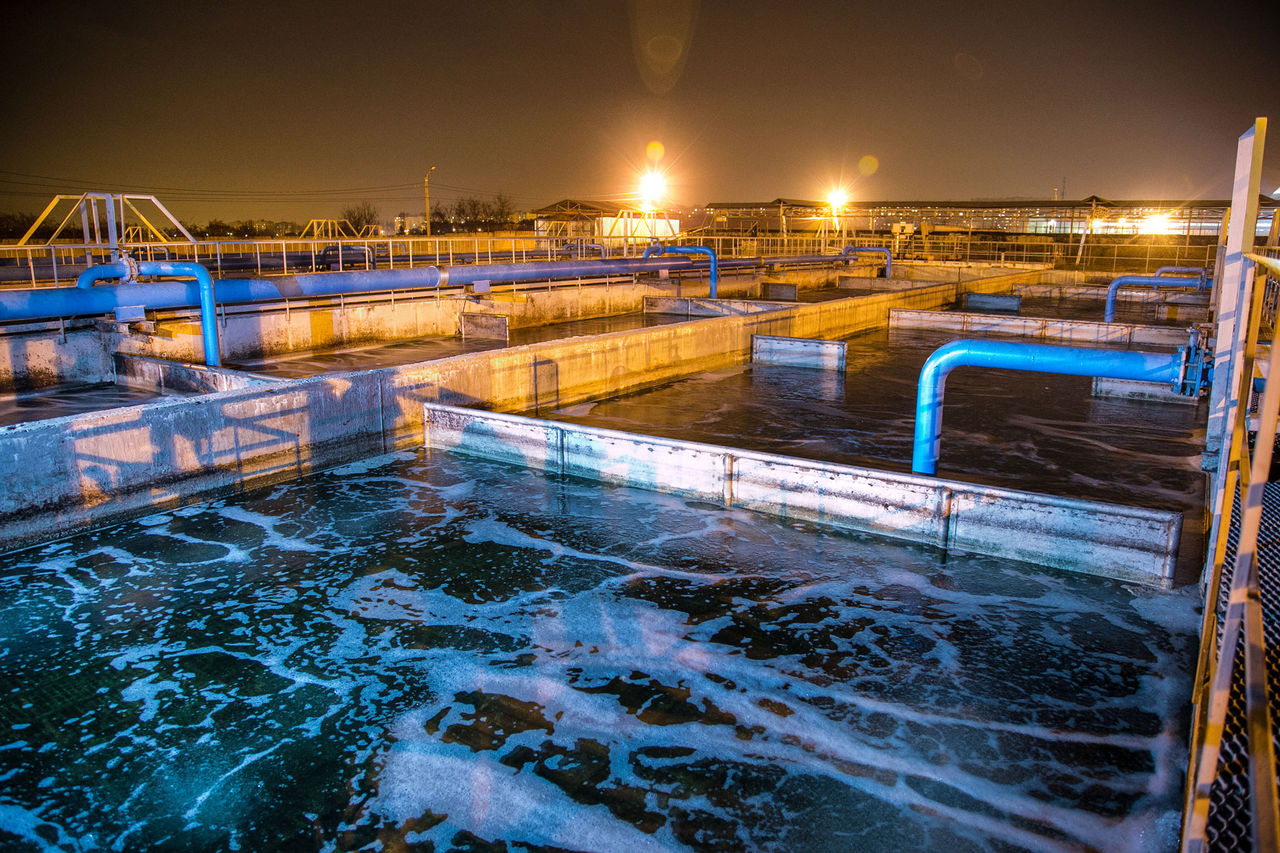 1053511 Modern wastewater treatment plant of chemical factory at night. Water purification tanks