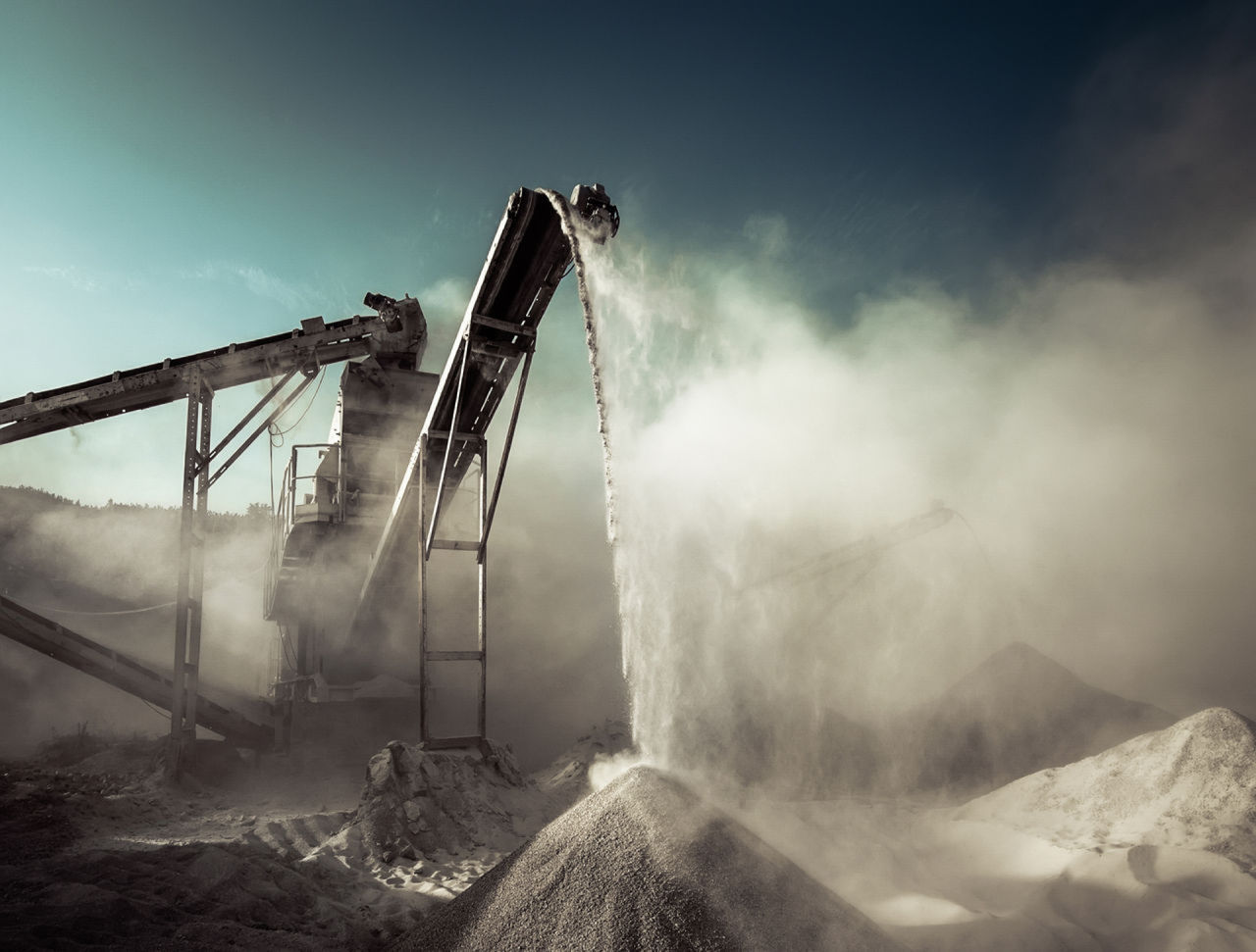 Mining or/and Quarrying machinery with a vibrant background and dusty dramatic clouds 